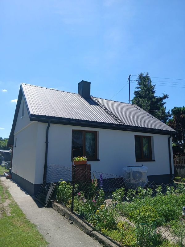 Biała elewacja z brązową stolarką